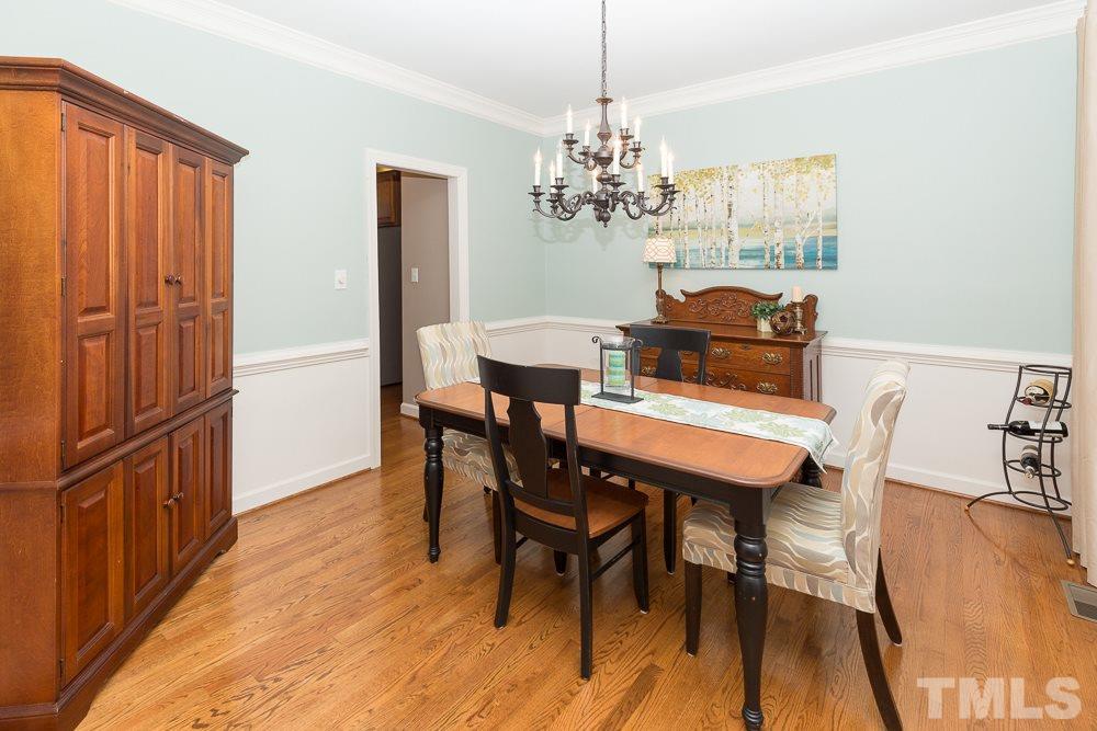 5817 North Hawthorne Way Raleigh, NC 27613 - Photo 2 of 25 a view of a dining room with furniture a chandelier and wooden floor