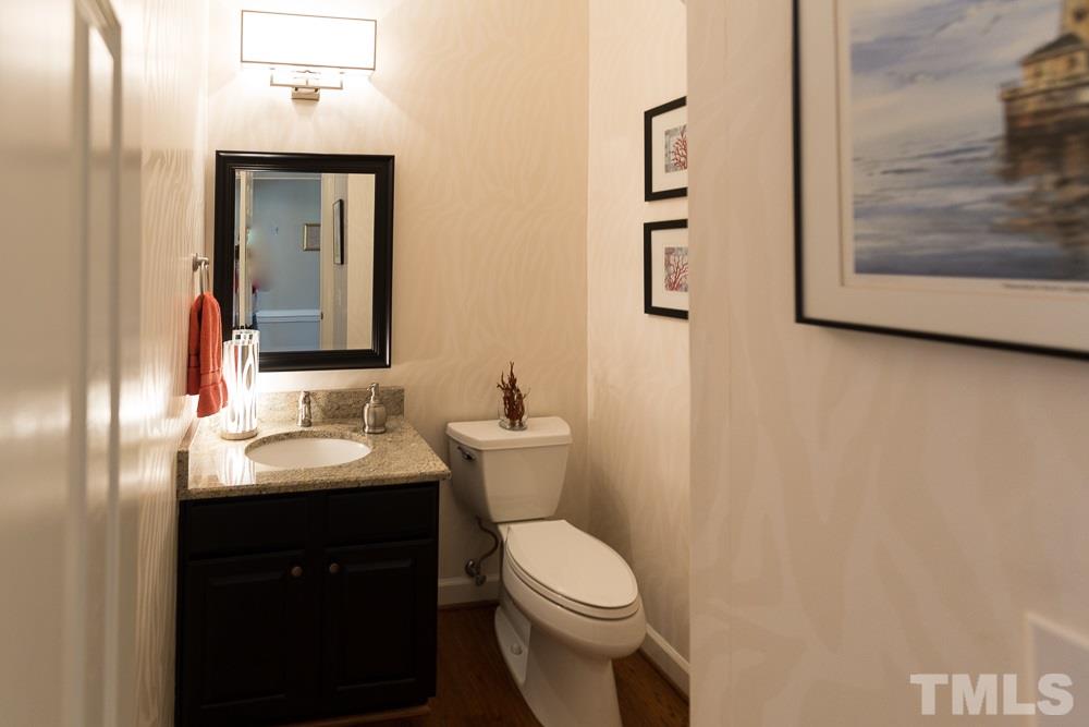5817 North Hawthorne Way Raleigh, NC 27613 - Photo 12 of 25 a bathroom with a toilet a sink and mirror