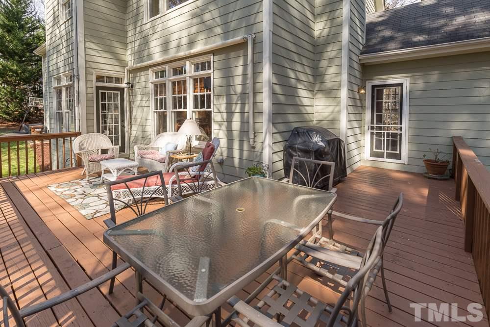 5817 North Hawthorne Way Raleigh, NC 27613 - Photo 23 of 25 a view of a patio with table and chairs with wooden floor and fence