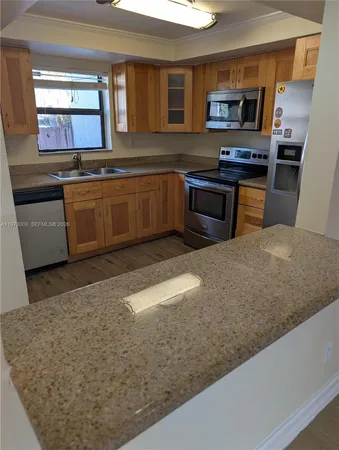 a kitchen with stainless steel appliances granite countertop a sink stove and microwave