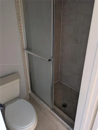 a white toilet sitting next to a shower