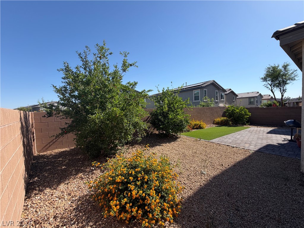 3228 Azalea Ridge Court Henderson, NV 89052 - Photo 25 of 28 A low-maintenance backyard retreat featuring a paver patio, artificial turf, and mature desert landscaping.