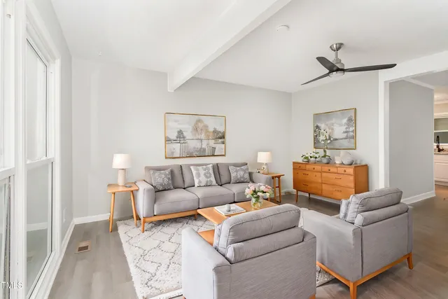 a living room with furniture and a painting on the wall