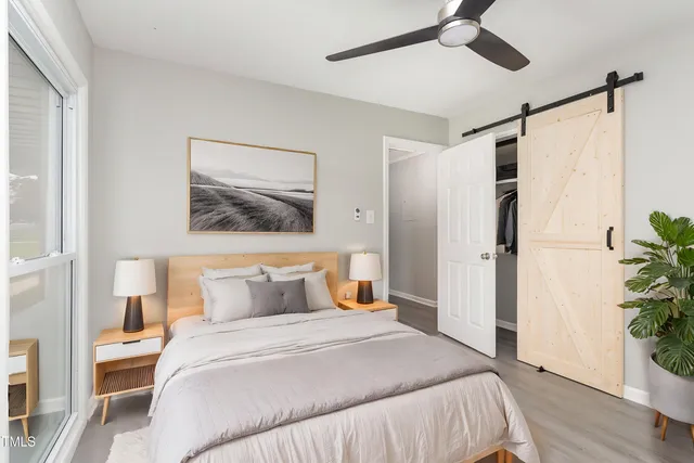 a bedroom with a large bed and a potted plant