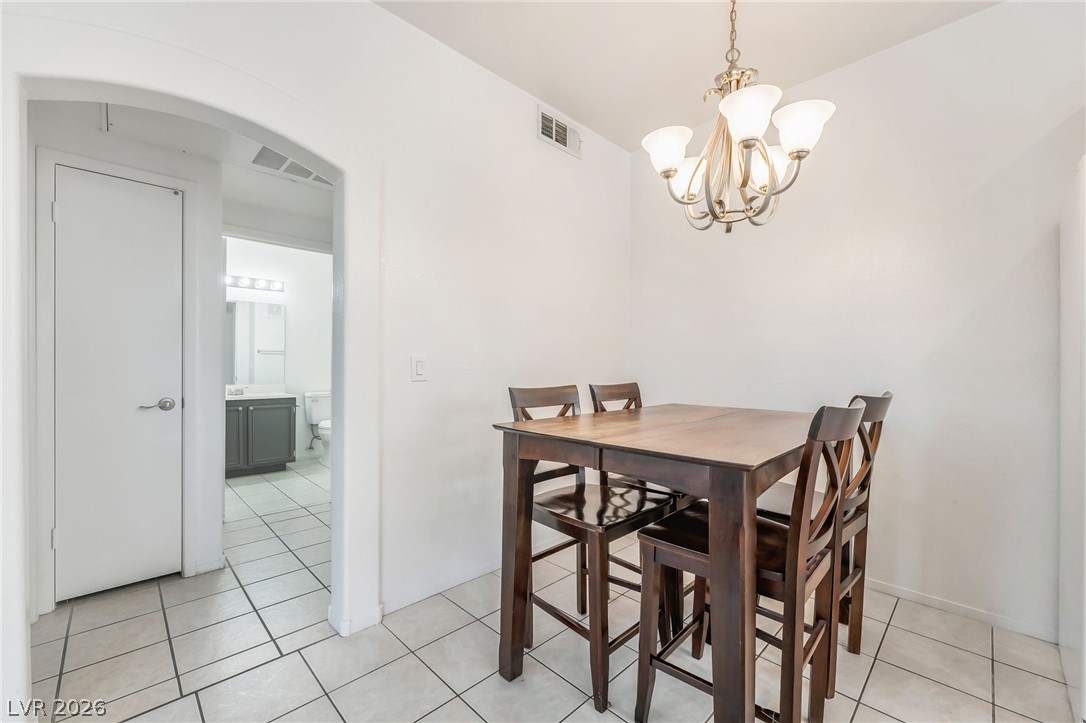 2201 Ramsgate Drive, Unit 811 Henderson, NV 89074 - Photo 8 of 36 A casual dining area features a pendant light fixture and tiled flooring, offering convenient access to a full bathroom.