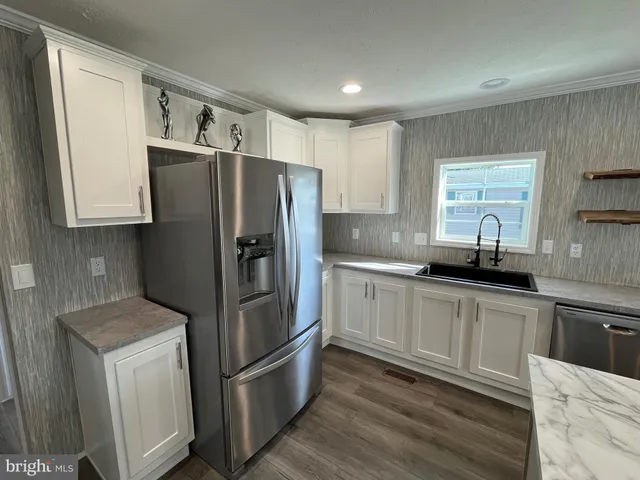 a kitchen with stainless steel appliances granite countertop a refrigerator sink and microwave