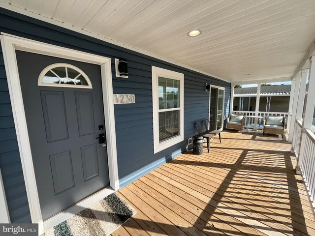 a view of a livingroom with wooden floor and furniture