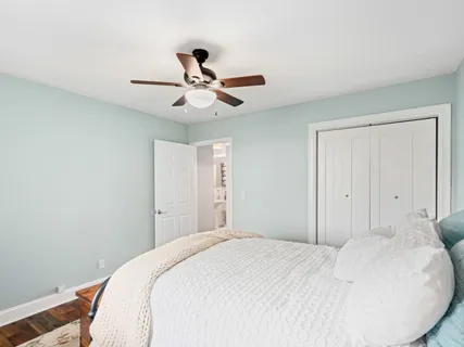 a bedroom with a large bed and a chandelier
