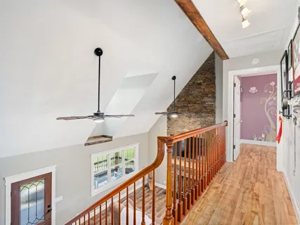 a view of a hallway with wooden floor and stairs