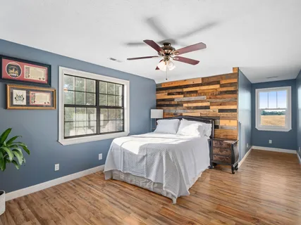 a bedroom with a bed and wooden floor