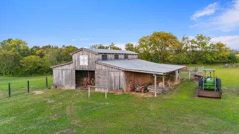 a view of a patio with table and chairs under an umbrella next to a yard