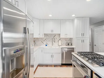a kitchen with a stove top oven sink and refrigerator