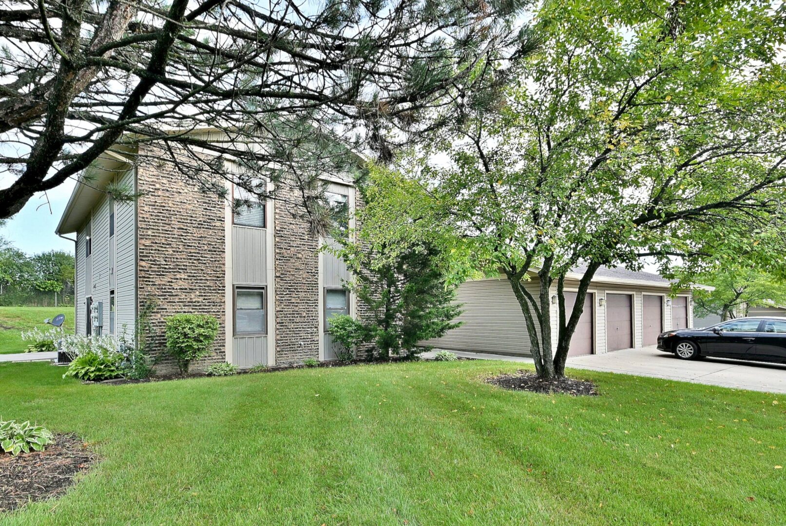 1395 Alpine Court, Unit C Hanover Park, IL 60133 - Photo 1 of 31 a front view of a house with a garden and trees