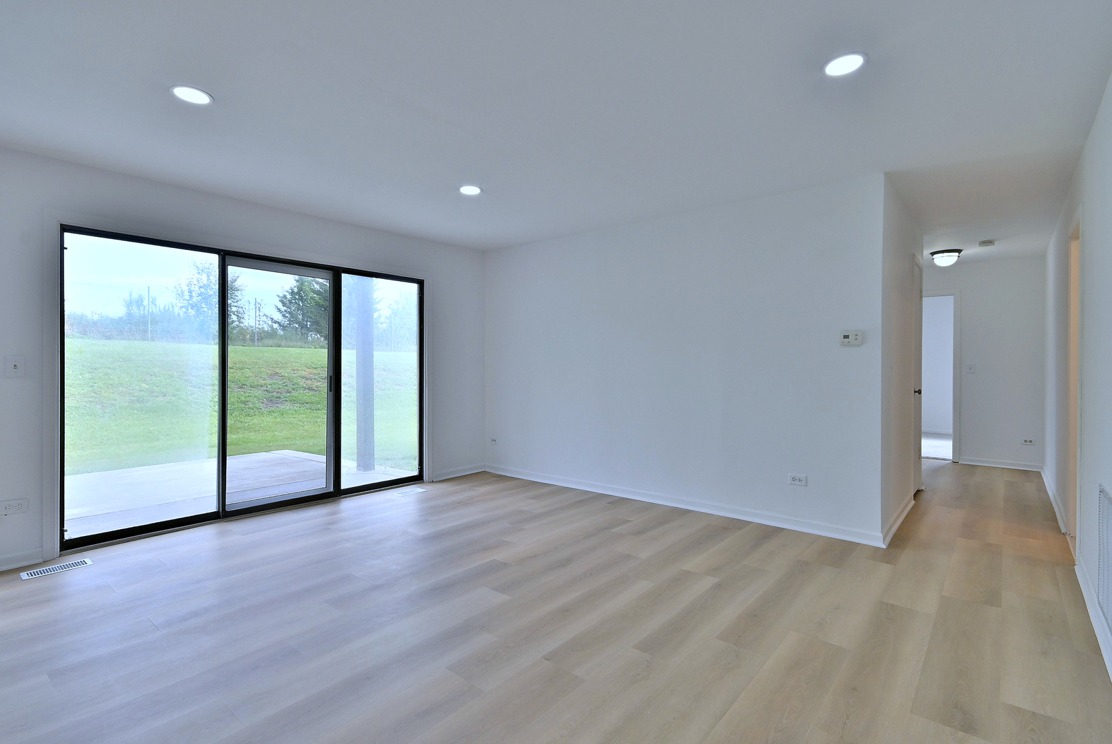 1395 Alpine Court, Unit C Hanover Park, IL 60133 - Photo 14 of 31 a view of an empty room with wooden floor and a window