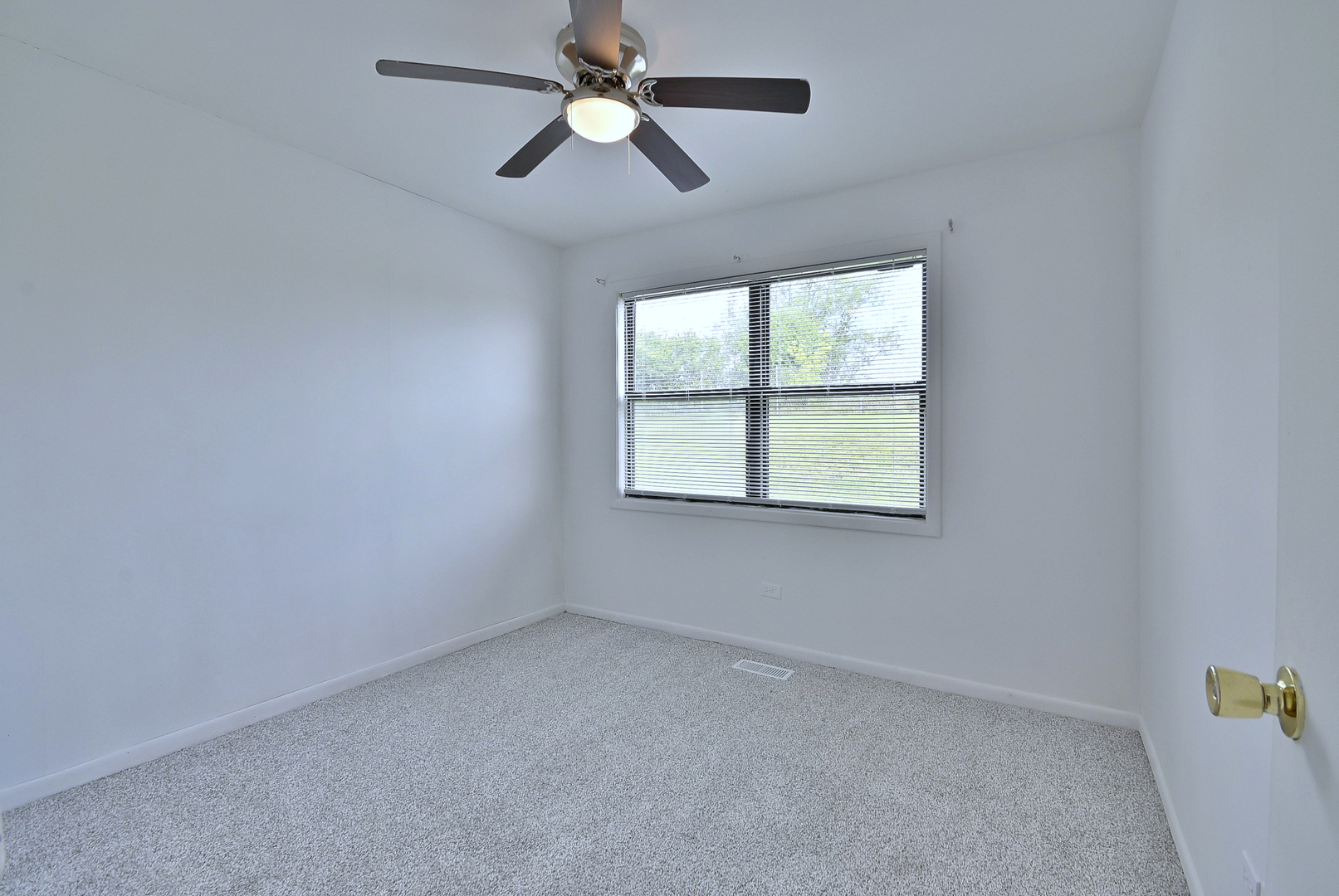 1395 Alpine Court, Unit C Hanover Park, IL 60133 - Photo 20 of 31 an empty room with a window and a fan