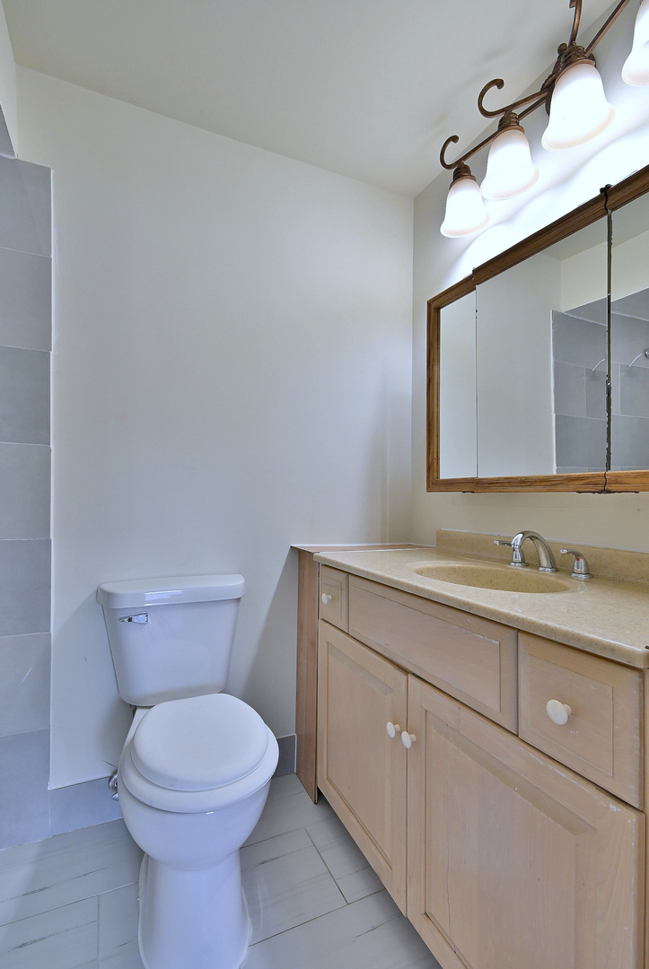1395 Alpine Court, Unit C Hanover Park, IL 60133 - Photo 26 of 31 a bathroom with a toilet sink and mirror