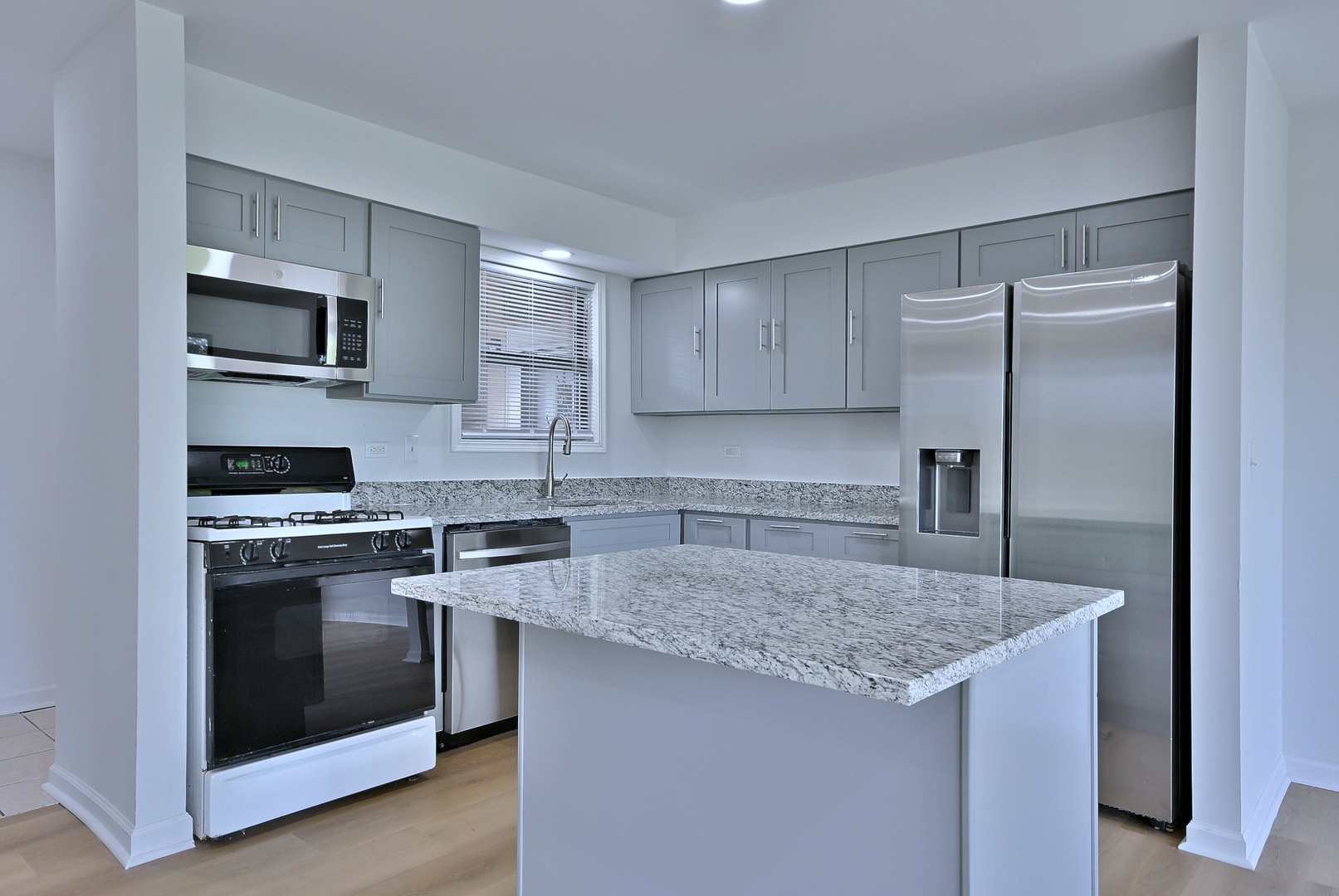 1395 Alpine Court, Unit C Hanover Park, IL 60133 - Photo 6 of 31 a kitchen with stainless steel appliances granite countertop a sink stove and refrigerator