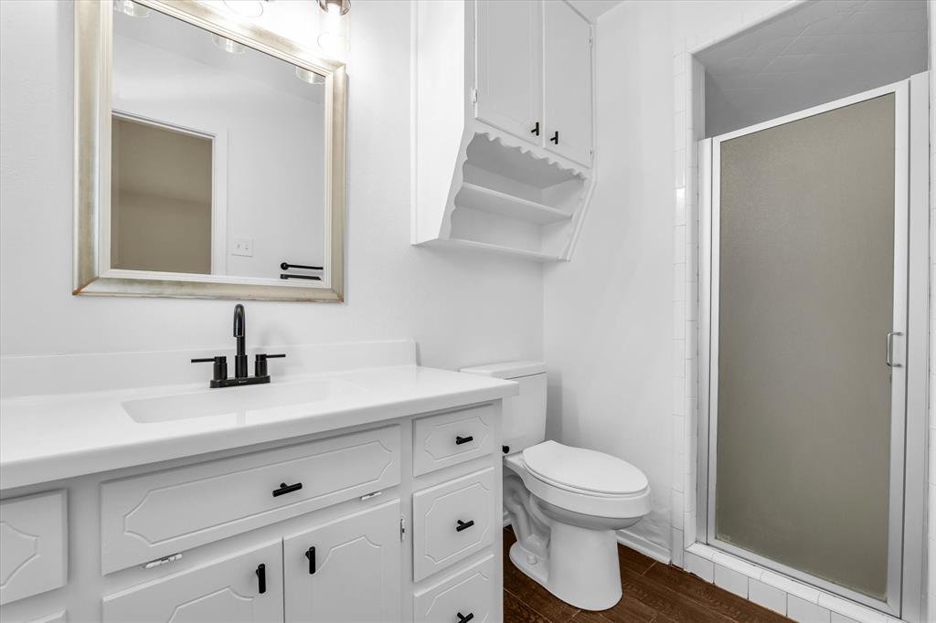 141 Travis Lane Hewitt, TX 76643 - Photo 19 of 31 Bathroom featuring a white vanity with integrated sink, black matte faucet, and framed mirror
