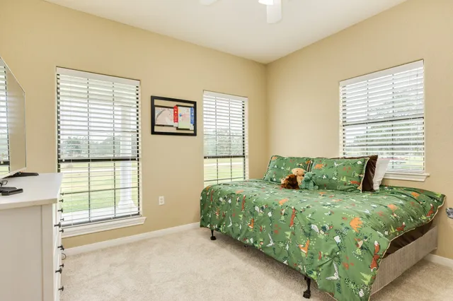 a bedroom with a bed and a large window