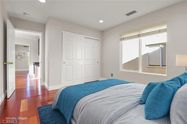 a view of a hallway with wooden floor and cabinets