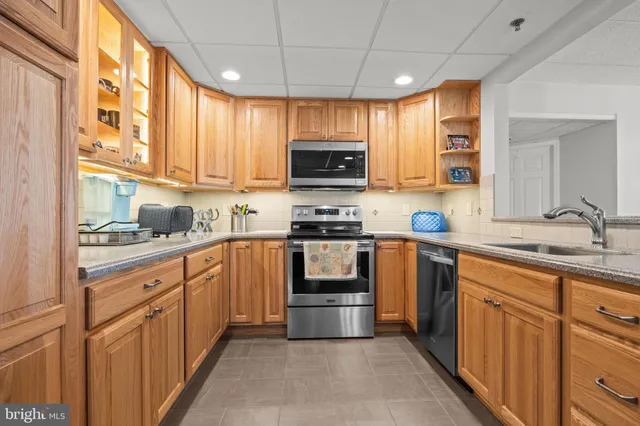 a kitchen with granite countertop a sink and steel appliances