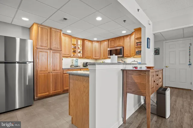 a kitchen with stainless steel appliances granite countertop a refrigerator a sink a stove and a refrigerator