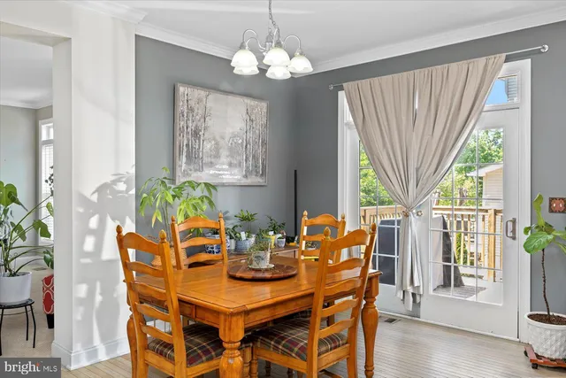 a dining room with furniture a large window and wooden floor