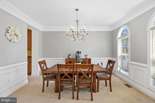 a view of a dining room with furniture a chandelier and wooden floor