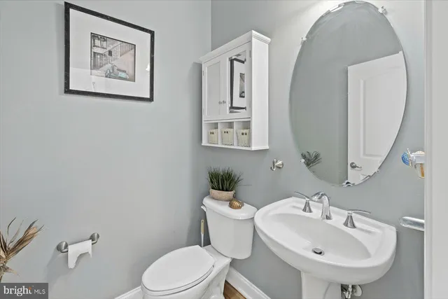 a bathroom with a toilet a sink and mirror