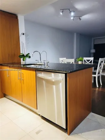 a view of a kitchen with kitchen island a sink wooden floor and black stainless steel appliances