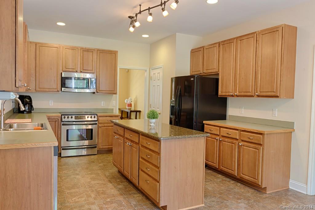 6312 Hastings Road Waxhaw, NC 28173 - Photo 4 of 24 a kitchen with stainless steel appliances granite countertop a refrigerator stove and sink