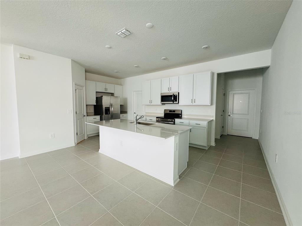 2473 Spring Tune Alley Kissimmee, FL 34744 - Photo 11 of 27 a kitchen with a sink a counter top space and cabinets