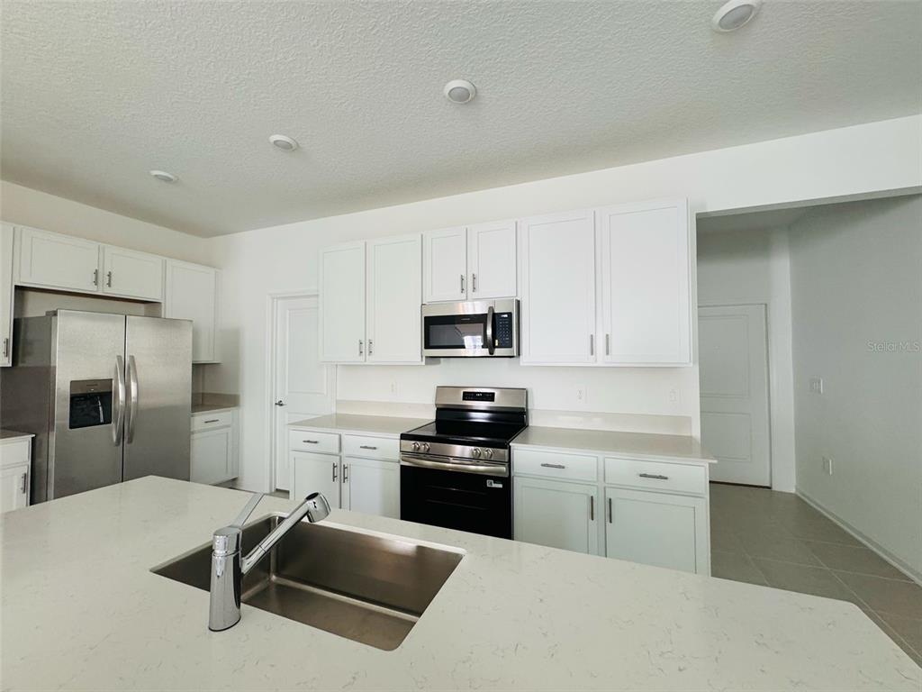 2473 Spring Tune Alley Kissimmee, FL 34744 - Photo 12 of 27 a kitchen with cabinets and stainless steel appliances