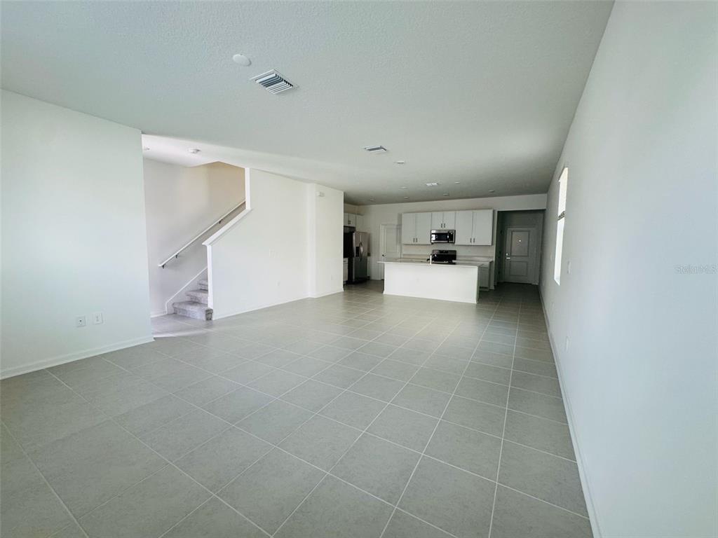 2473 Spring Tune Alley Kissimmee, FL 34744 - Photo 13 of 27 a view of a livingroom and a kitchen with furniture and a window