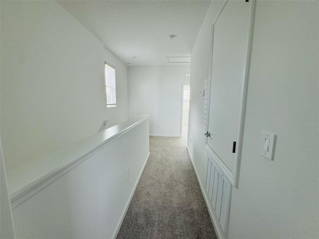 2473 Spring Tune Alley Kissimmee, FL 34744 - Photo 17 of 27 a view of a hallway with white walls