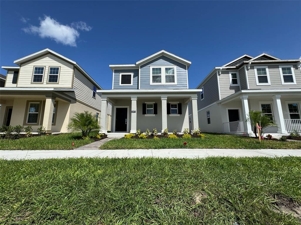 2473 Spring Tune Alley Kissimmee, FL 34744 - Photo 3 of 27 a front view of a house with a yard