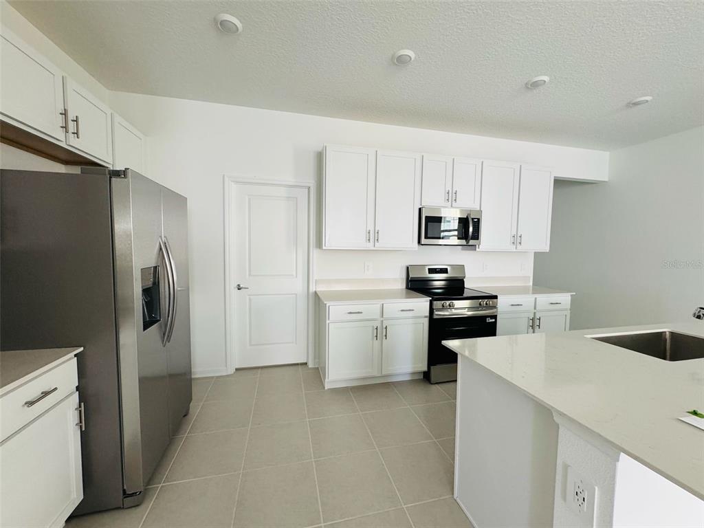 2473 Spring Tune Alley Kissimmee, FL 34744 - Photo 10 of 27 a kitchen with a refrigerator stove and sink