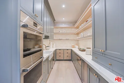 a kitchen with a sink and wooden floor