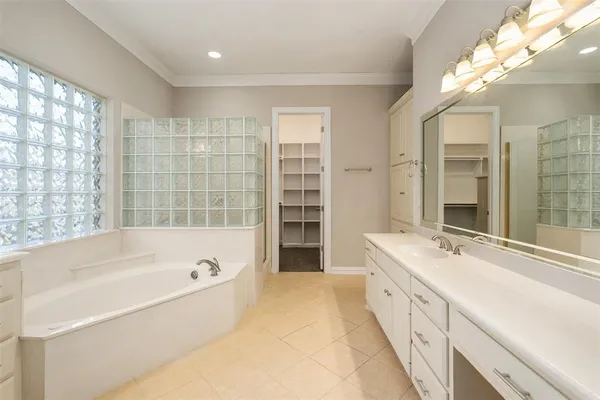 a spacious bathroom with a tub sink shower and a mirror