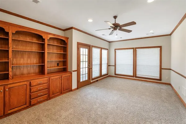 a view of an empty room with a window and a ceiling fan
