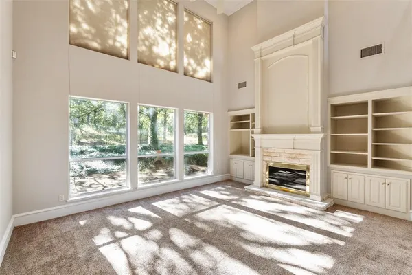 a view of empty room with windows and fireplace