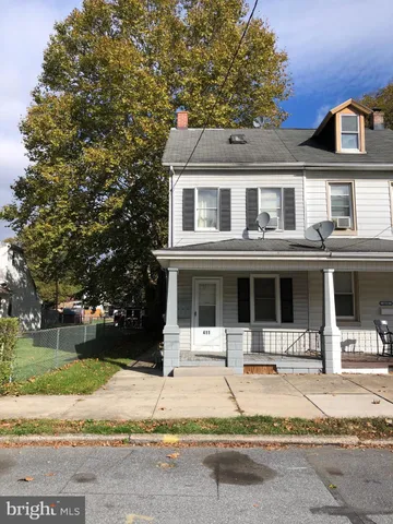 a front view of a house with porch and yard