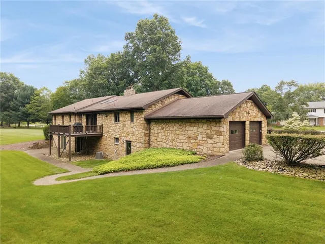 an aerial view of residential houses with outdoor space and trees