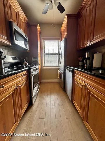 a kitchen with granite countertop a sink a counter space cabinets and stainless steel appliances