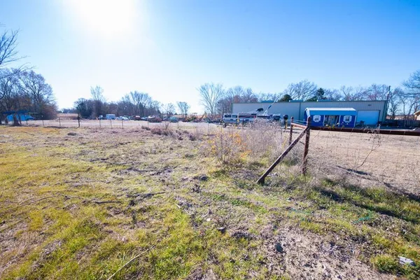 a view of a dry yard with wooden fence