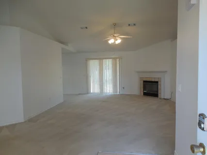 an empty room with windows and fireplace