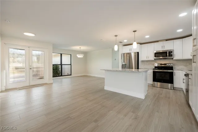 a view of kitchen with wooden floor and electronic appliances