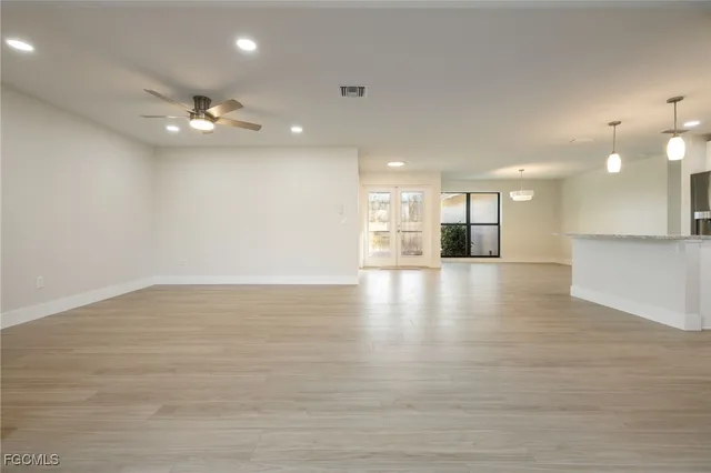 a view of empty room with wooden floor