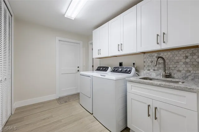 a view of cabinets a sink and dishwasher with wooden floor