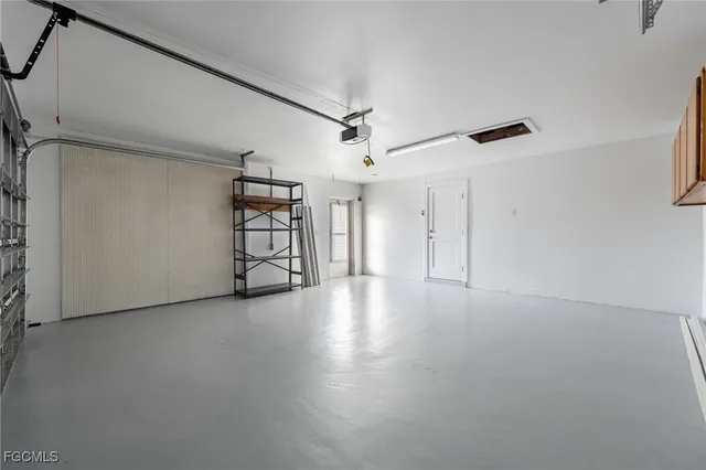 a view of an empty room with a window and a kitchen